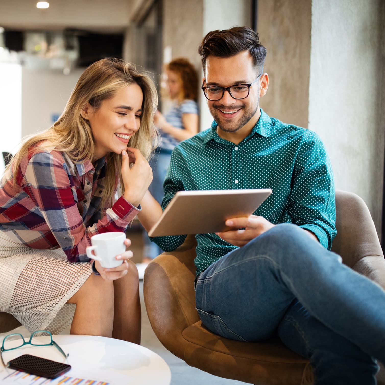 Colegas de trabalho em um escritório, trabalhando com segurança em um tablet com a ajuda do gerenciamento de dispositivos móveis do GoTo Resolve.